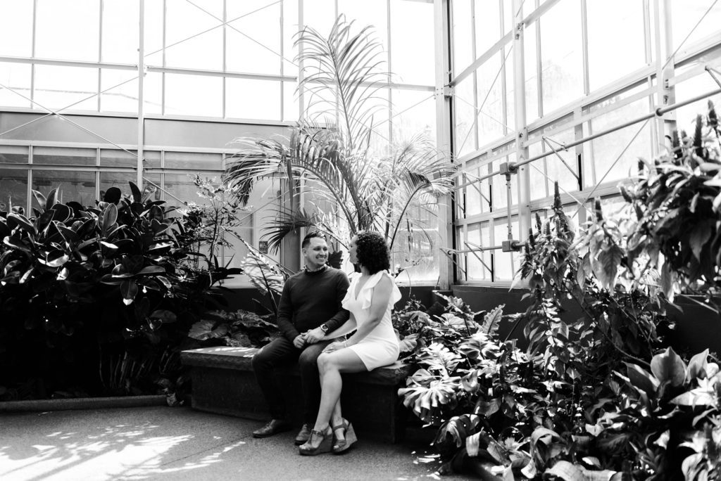 Lauren and Matthew on bench in greenhouse during their engagement session