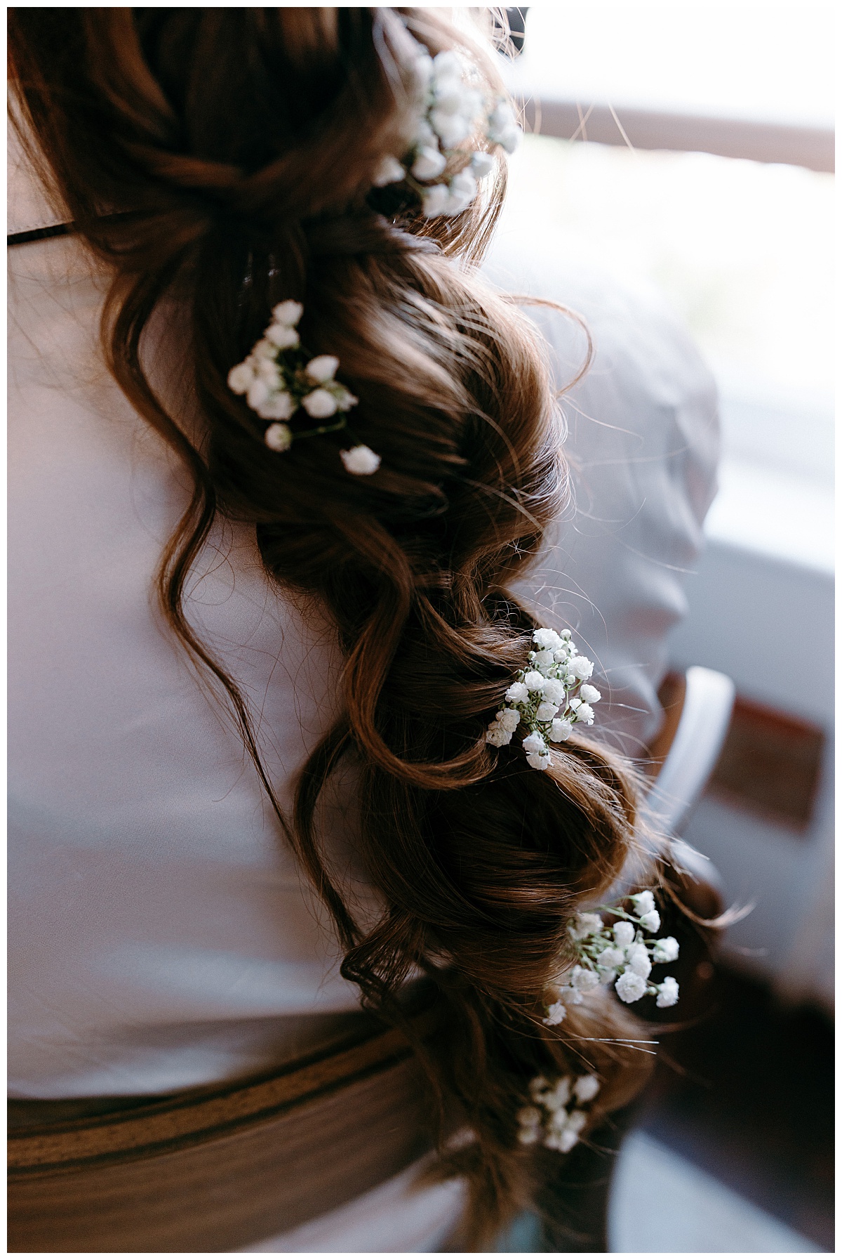 brown hair braided loosely with baby's breath tucked in by North Carolina wedding photographer