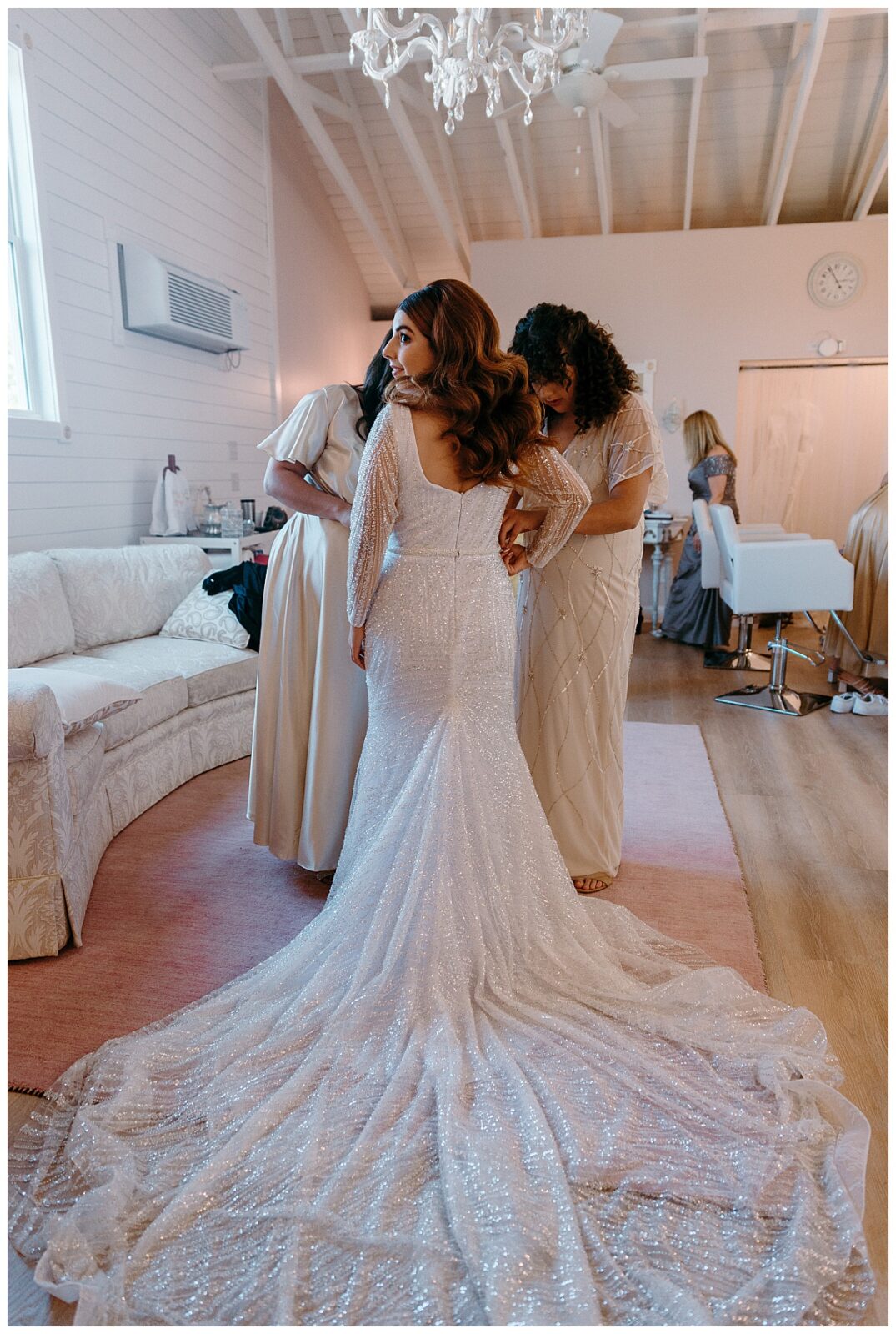 family help bride put on gown by North Carolina wedding photographer