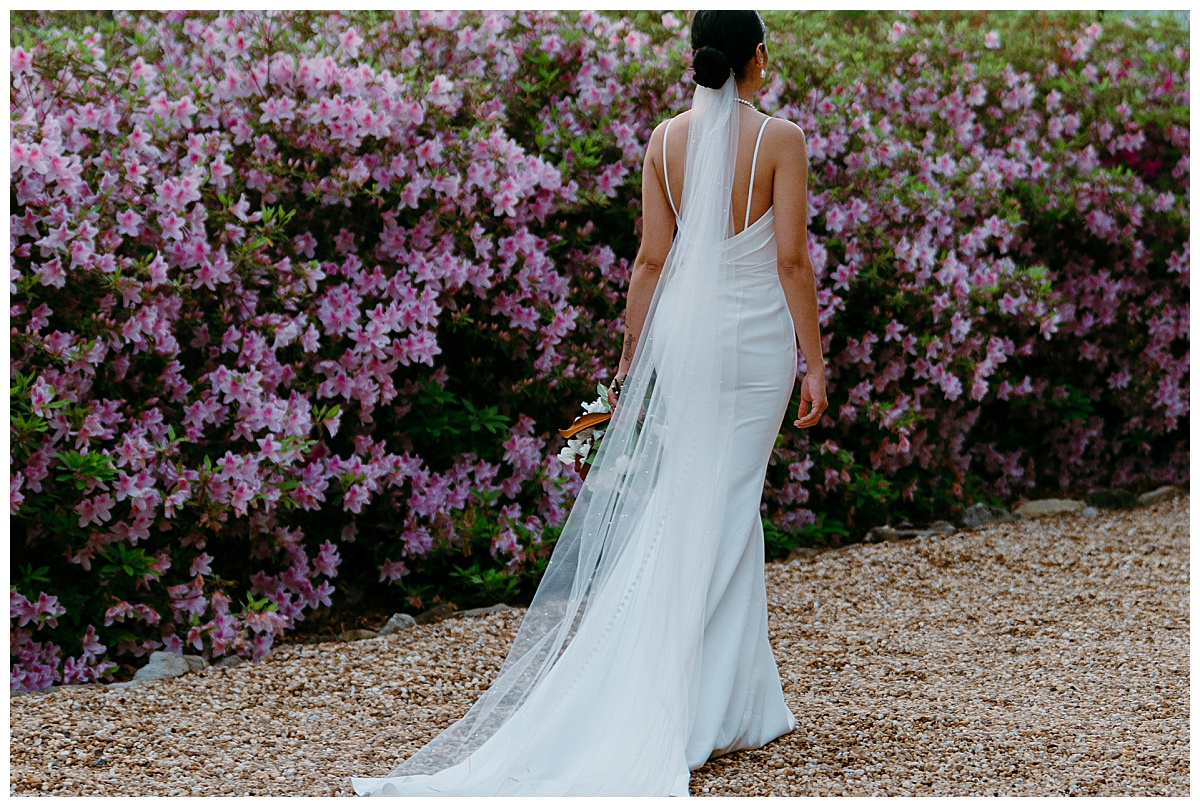 woman walking away near floral bush at VanLandingham Estate bridal session