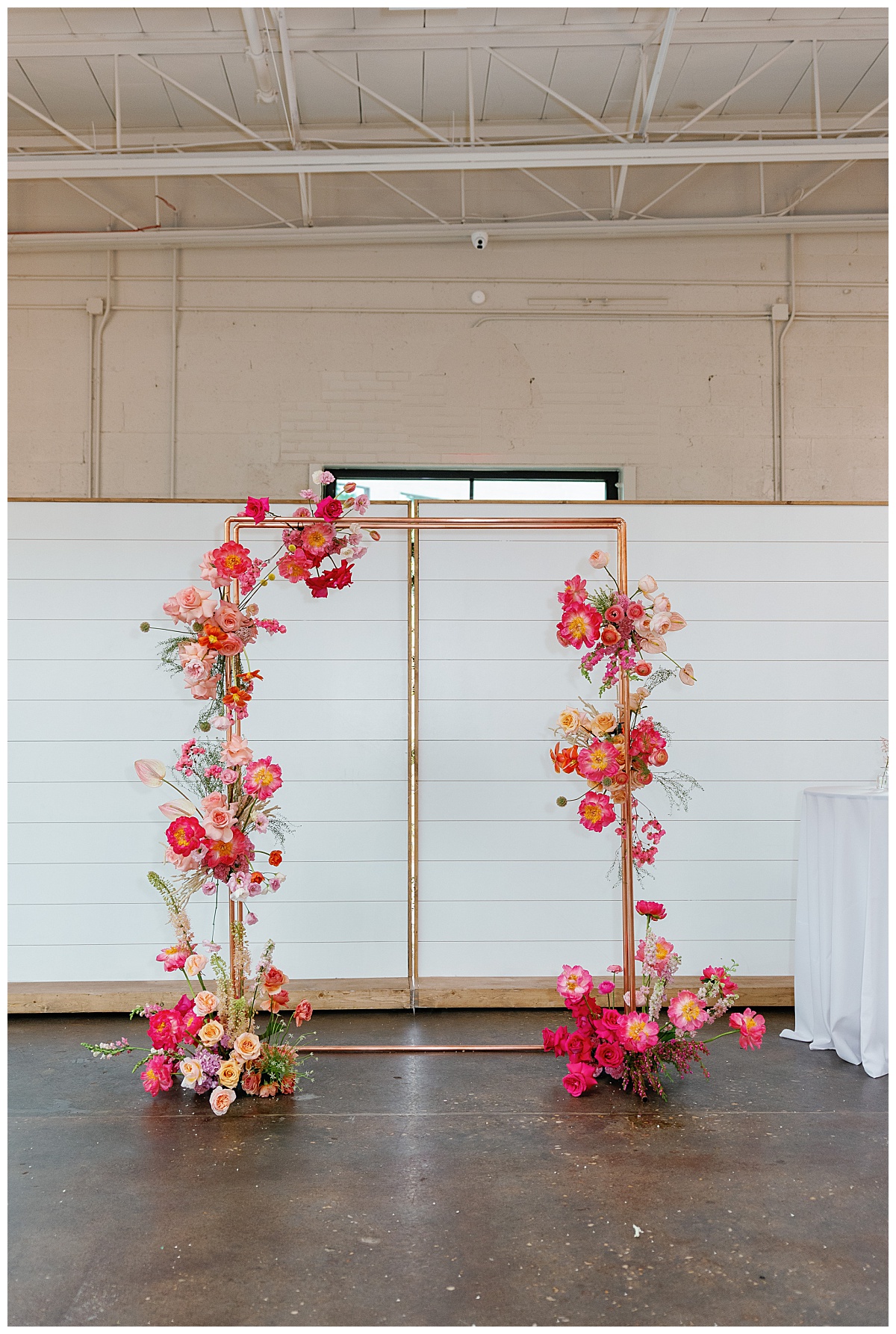 bright florals decorate ceremony arch at The Ruth