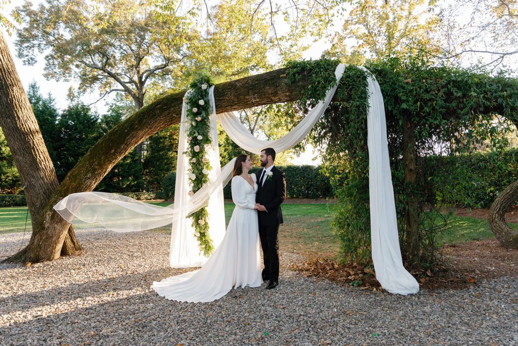 Bride and groom beneath arbor at Whitehead Manor Wedding.